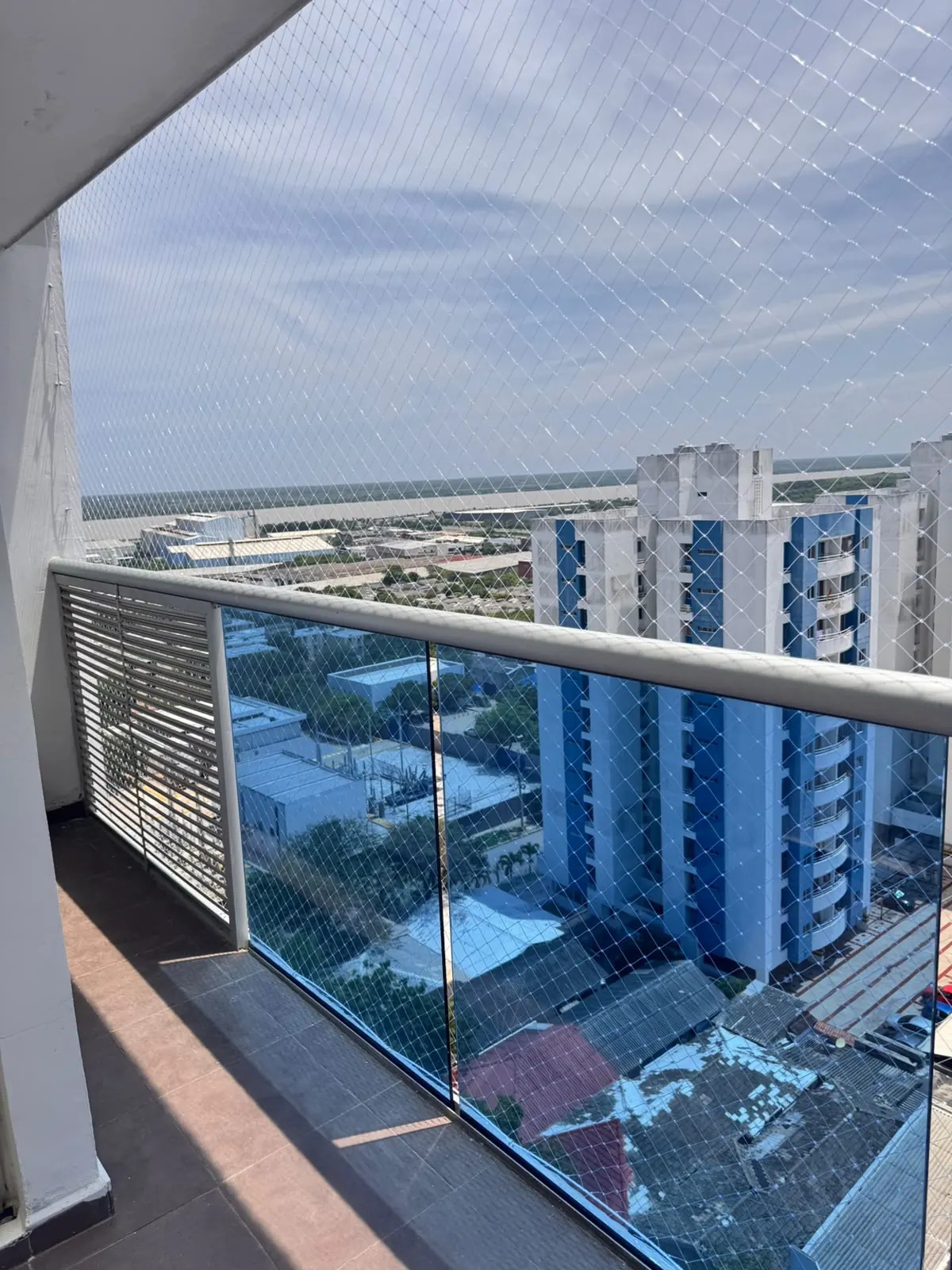 Balcón de apartamento con malla de seguridad instalada y vista a la ciudad de Barranquilla